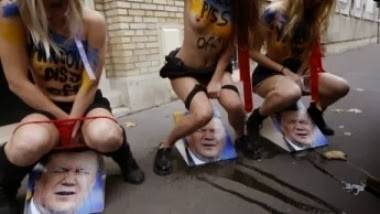 ناشطات فيمن يتبولن على صورة الرئيس الأوكراني للتنديد بقمع المتظاهرين الأوكرانيين