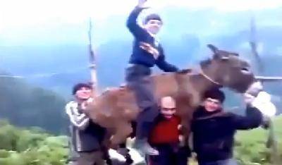 بالفيديو: شاب يثبت قوته بحمله حماراً مع شاب يمتطيه