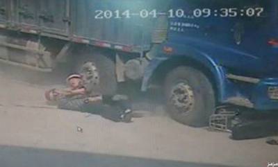 صور: صيني يضحي بحياته تحت عجلات شاحنة إنقاذاً لابنه