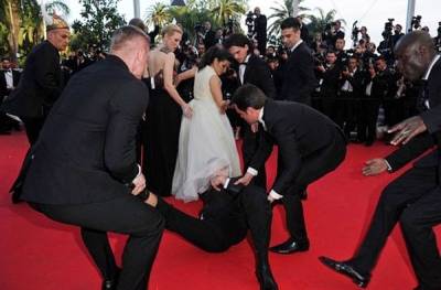 صور.. صحفي يقحم رأسه داخل فستان ممثلة في كان