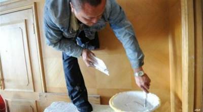 صور: صيني بساق واحدة يتحدى الإعاقة ويعمل في طلاء المنازل