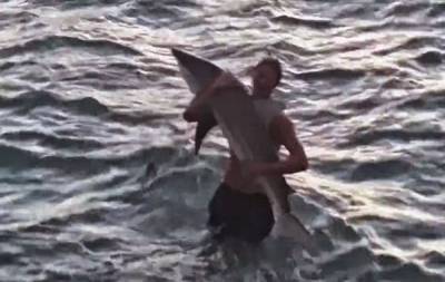 لا يصدق : شاب يصطاد سمكة قرش بيده .. فيديو