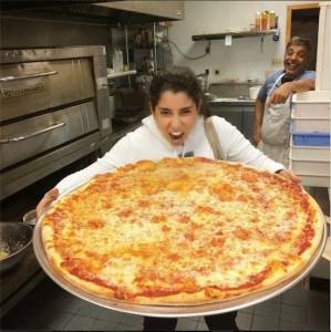 صورة آيتن عامر تحمل بصينية بيتزا كبيرة