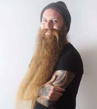 صور: عشريني يُلقّب بصاحب أطول لحية في بريطانيا