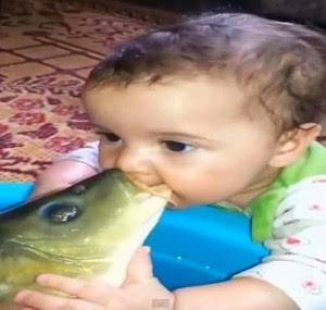 فيديو طريف : قبلات متبادلة بين طفل وسمكة حية