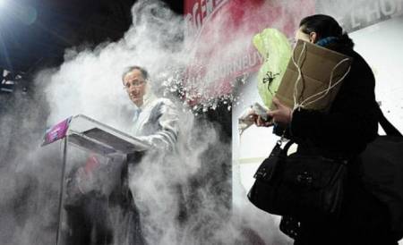 فتاة ترشق الرئيس الفرنسي بـبودرة في مؤتمر صحفي (فيديو)