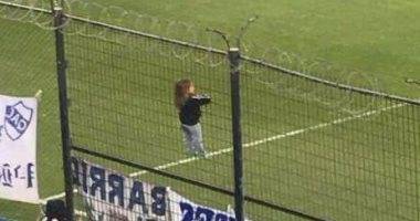 طفلة تتسلق سياجا حديديا لمساندة فريقها بالأرجنتين