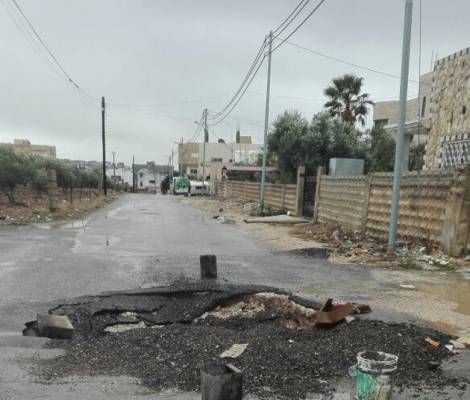 رقباء سير يردمون حفرا سببتها مياه الأمطار (صور)