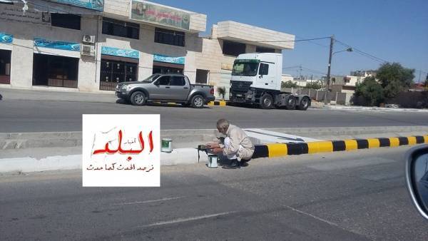 ستيني يتطوّع بدهان أطراف شوارع مدينة معان (صور)