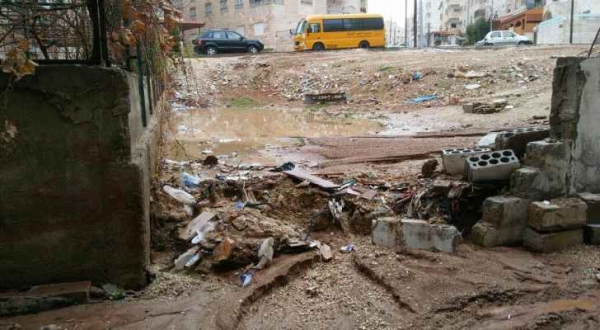 مياه الأمطار تداهم منزلا في طبربور اثر انهيار جسر استنادي.. صور