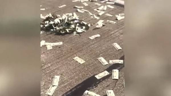 السماء تمطر دولارات حقيقية فوق شارع مزدحم! (فيديو)