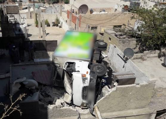 تدهور مركبة واستقرارها على سطح منزل في عمان (صور)
