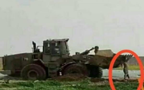 جرافة إسرائيلية تنكل بجثمان شهيد فلسطيني في قطاع غزة (فيديو)