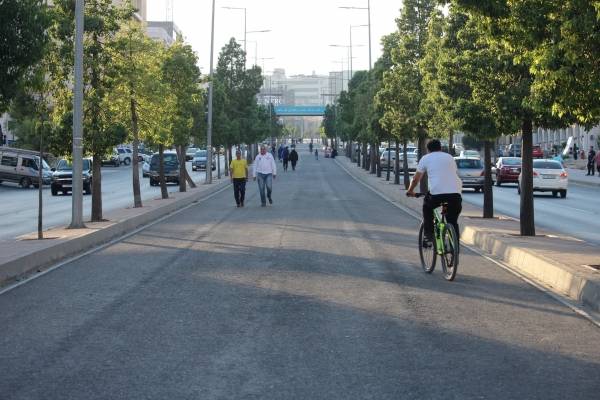 عربة بيع الذرة والفوشار والدراجات النارية والهوائية تسبق الباص السريع في شارع الجامعة