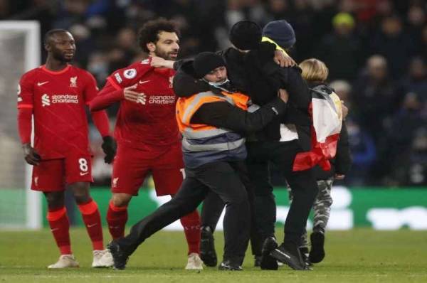 مشجع يقتحم ملعب مباراة ليفربول حاملا علم مصر ويتشبث بمحمد صلاح