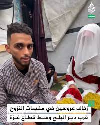 عروسان فلسطينيان من غزة يقيمان حفل زفافهما في مخيمات النزوح قرب دير البلح وسط أهازيج فلسطينية تحيطهما من النازحين